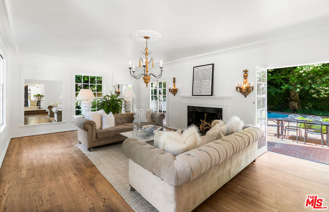 949 Stone Canyon Road Los Angeles, CA 90077 - Photo 8 of 41 a living room with furniture a flat screen tv and a fireplace