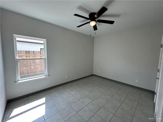 an empty room with a window and a fan