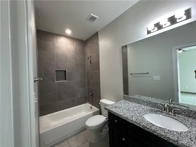 a bathroom with a granite countertop sink toilet and shower