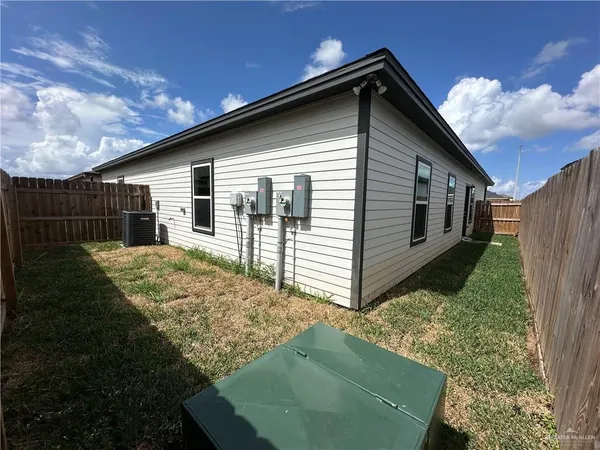 a view of backyard of house with wooden fence