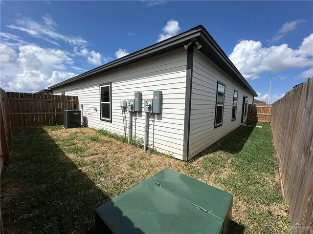 a view of backyard of house with wooden fence
