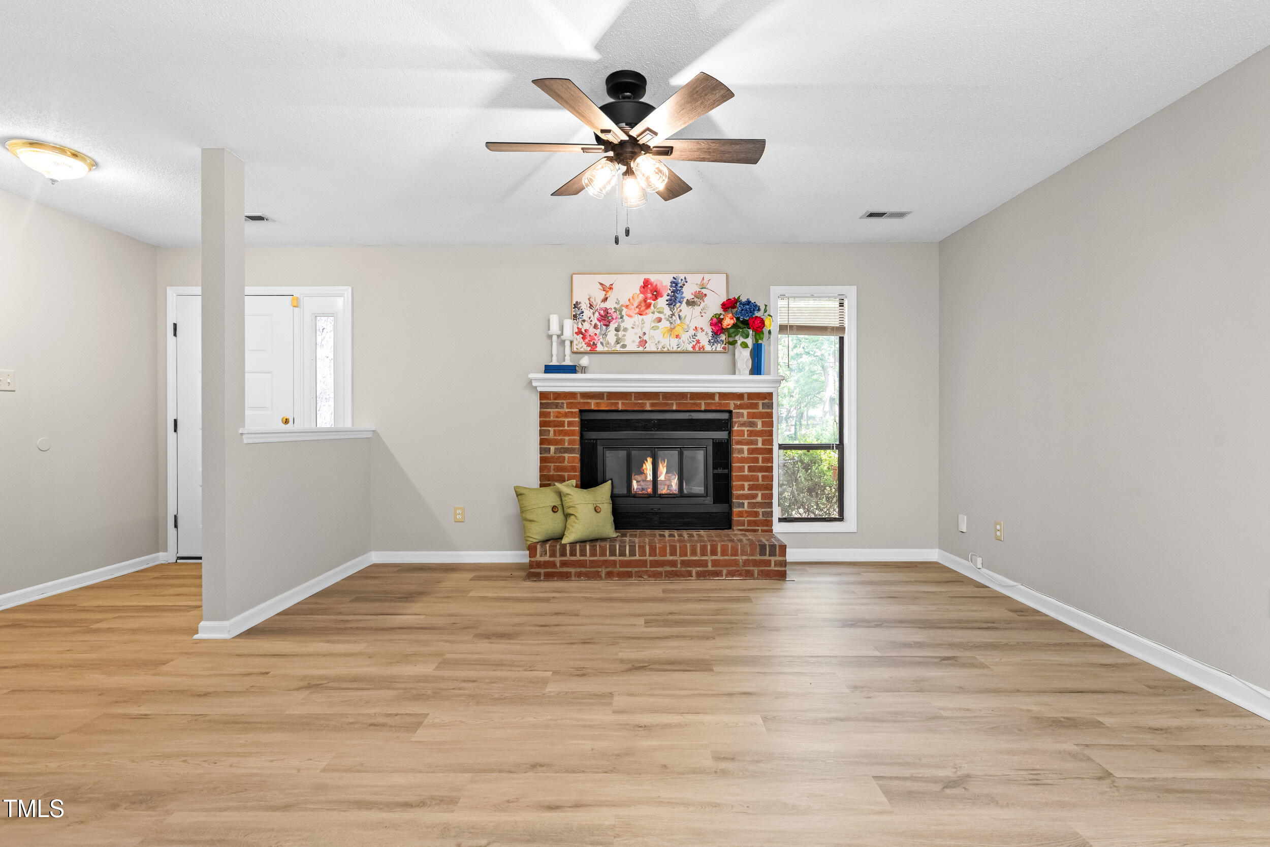 232 Clancy Circle Cary, NC 27511 - Photo 2 of 14 wooden floor fireplace and window in an empty room