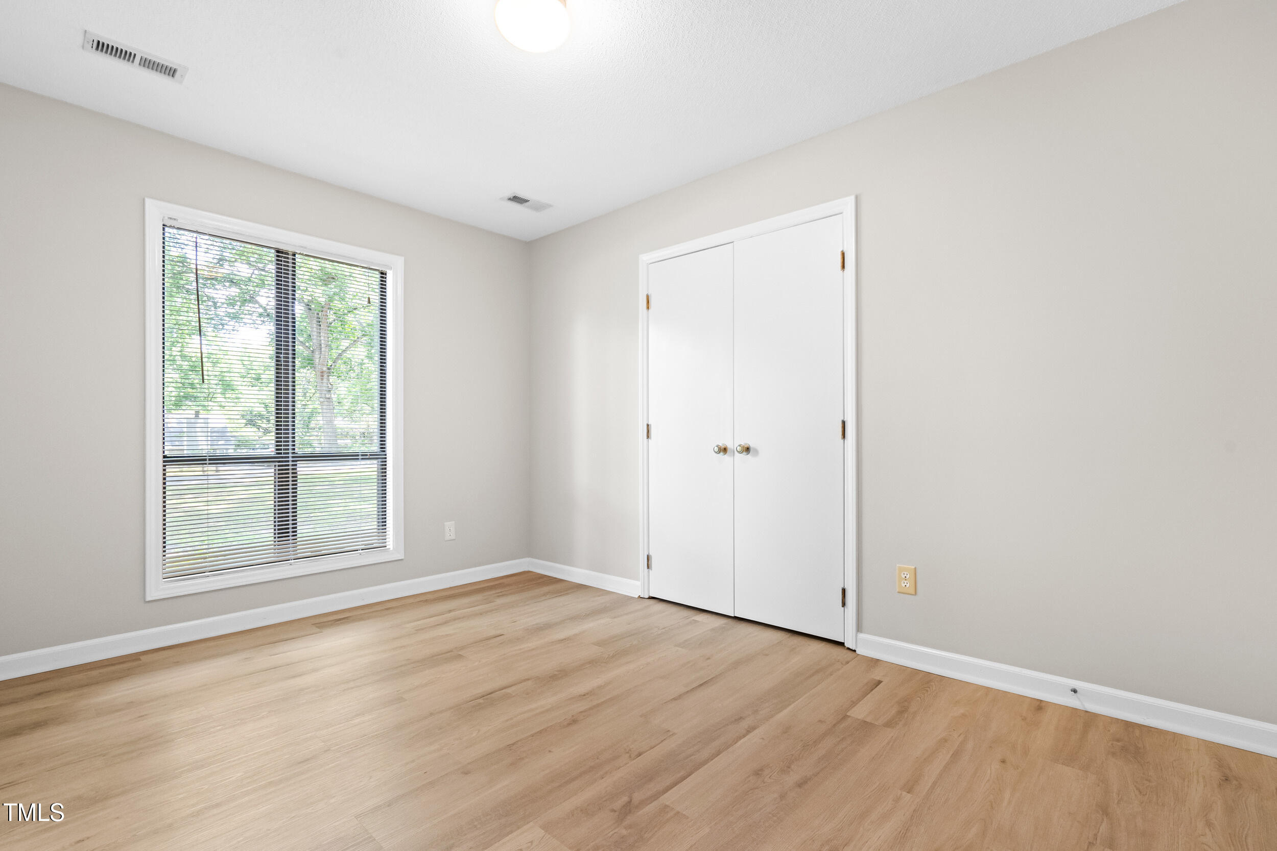 232 Clancy Circle Cary, NC 27511 - Photo 7 of 14 an empty room with wooden floor and windows
