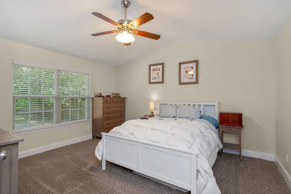 a bedroom with a bed a chandelier and a window