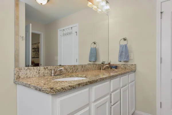 a bathroom with a granite countertop sink and a mirror