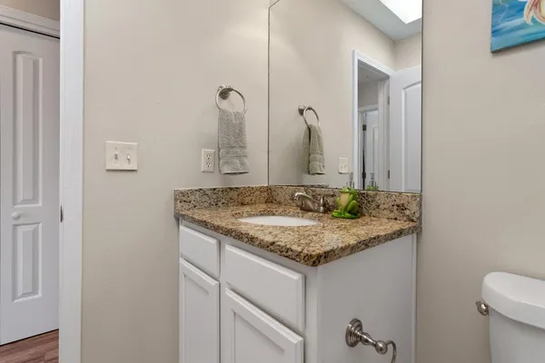 a bathroom with a granite countertop sink and a mirror