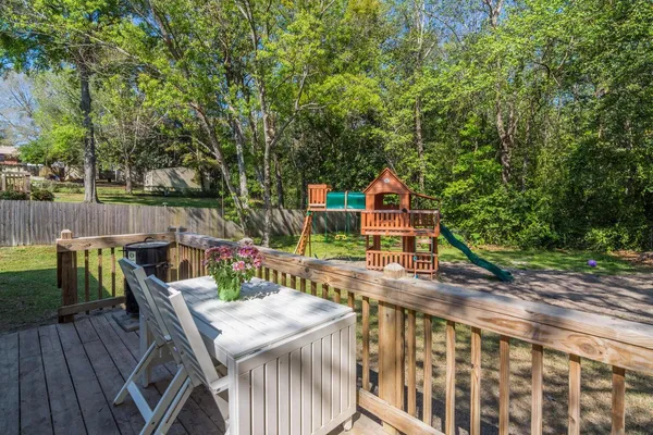 a view of deck with furniture and trees