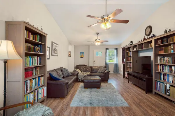 a living room with furniture and a book shelf