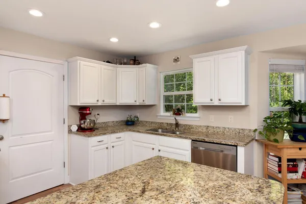 a kitchen with granite countertop a sink stainless steel appliances and cabinets