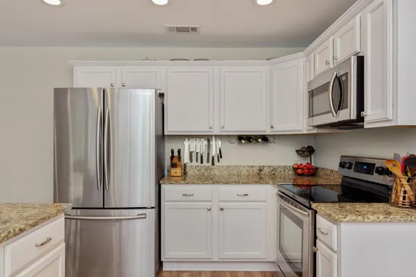 a kitchen with granite countertop stainless steel appliances and refrigerator