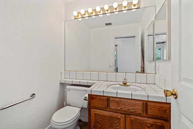 a bathroom with a sink toilet vanity and mirror