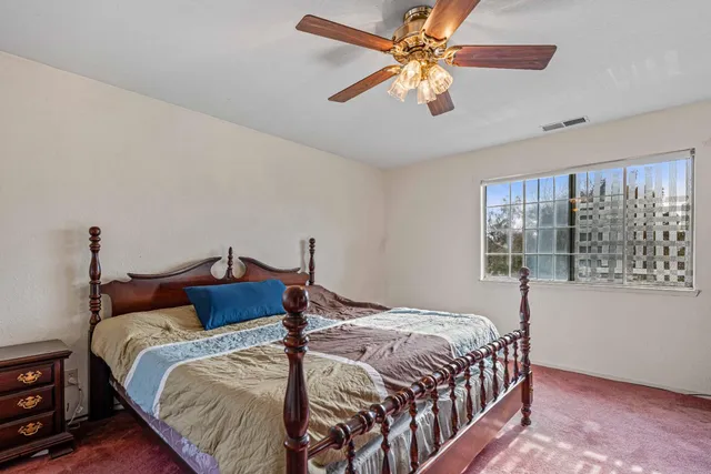a bedroom with a bed a chandelier and a window