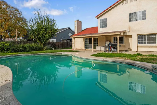 a front view of a house with swimming pool having outdoor seating