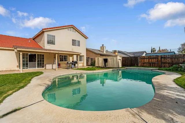 a view of a white house with a sink and a yard