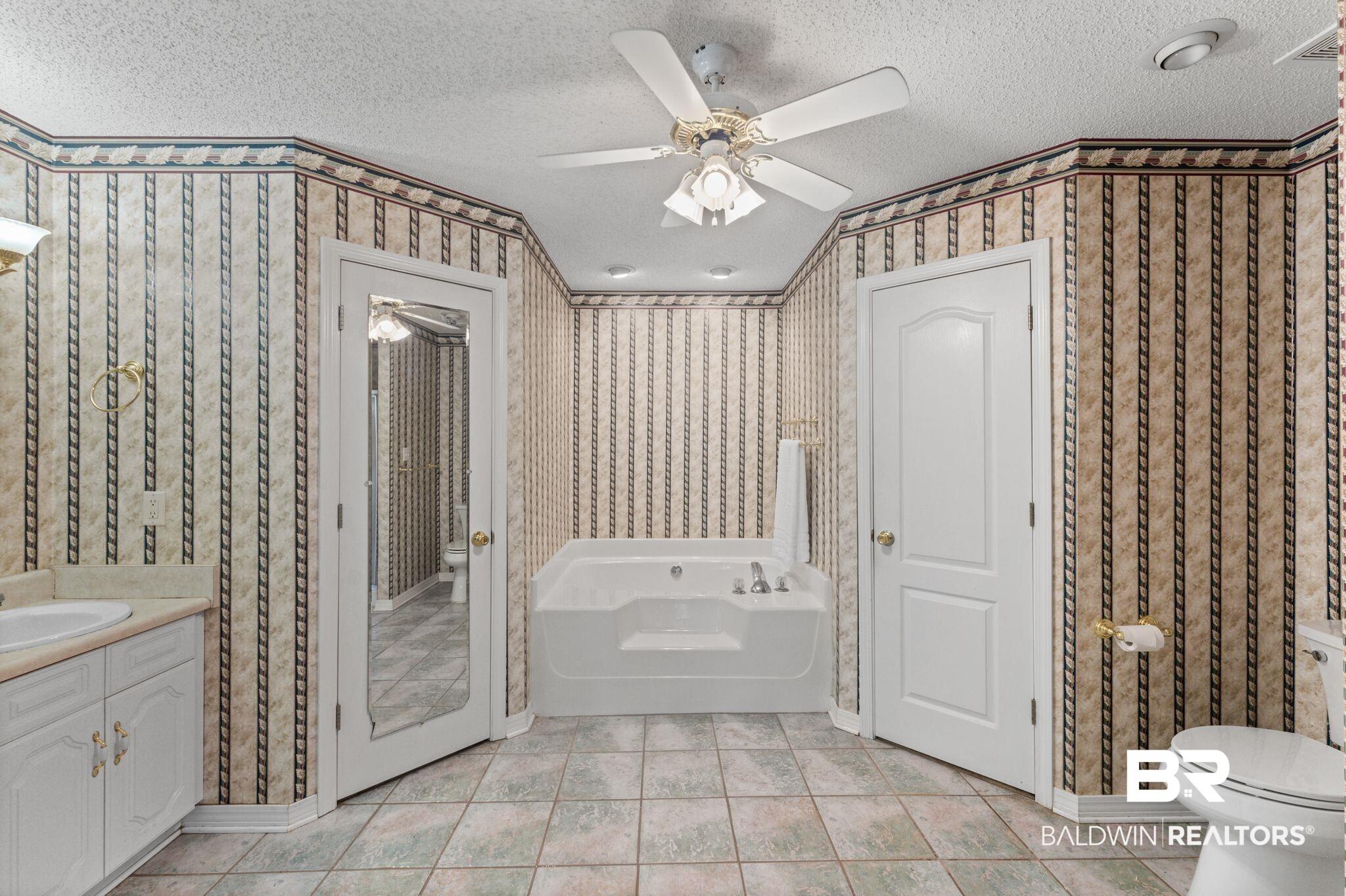 888 Mobile Cut-Off Road St. Stephens, AL 36569 - Photo 25 of 54 Full bathroom featuring a garden tub, vanity, a textured ceiling, ceiling fan, and light tile patterned flooring
