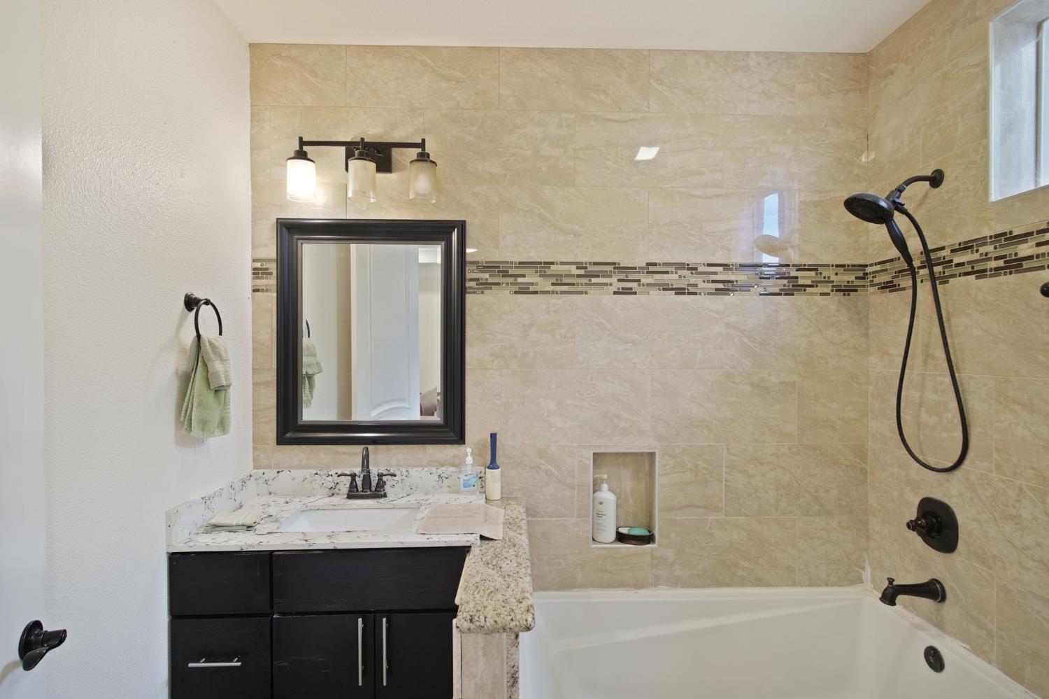 3205 Hillglen Avenue Modesto, CA 95355 - Photo 20 of 45 a bathroom with a bath tub sink mirror and vanity