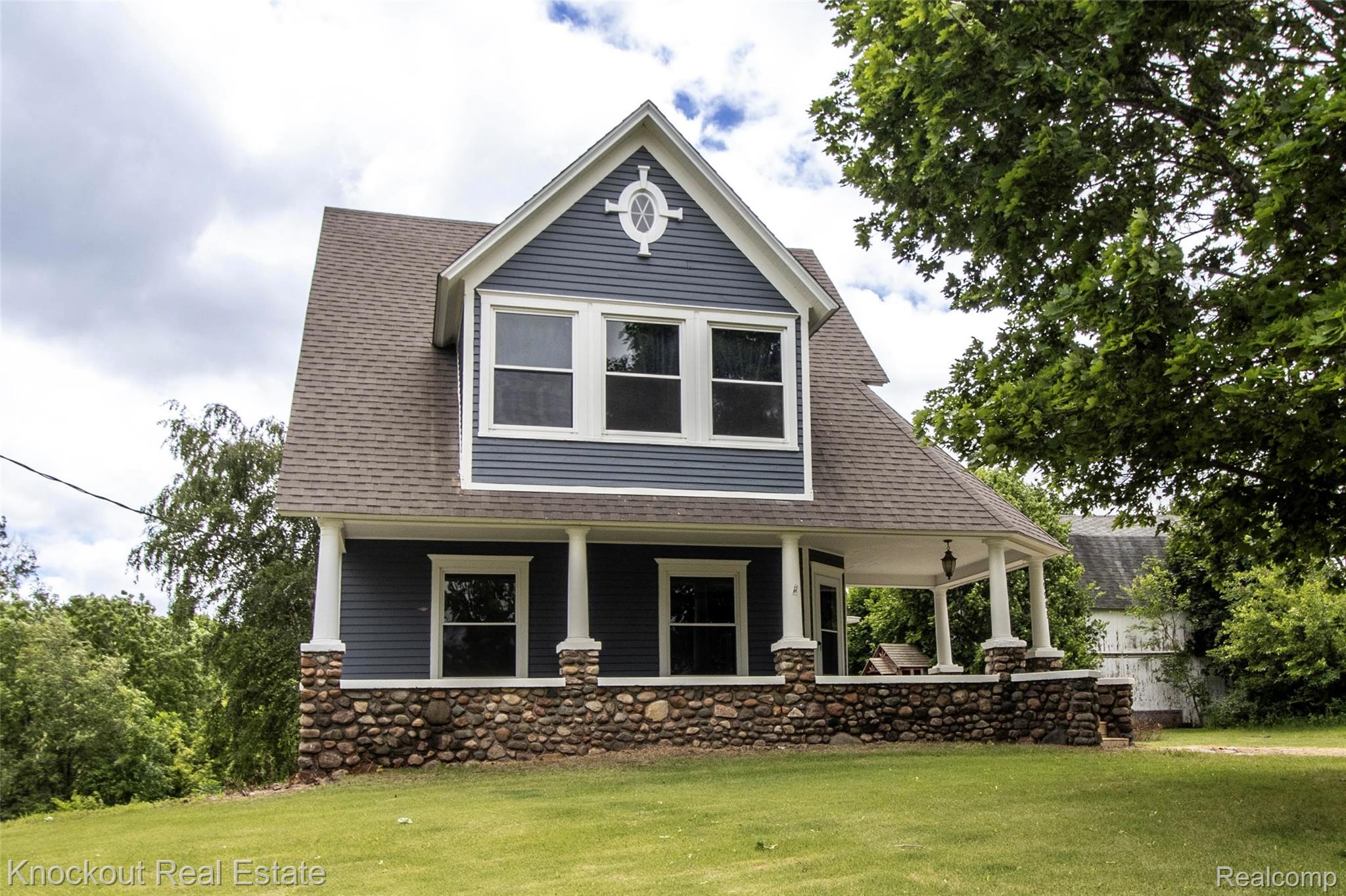 19983 West Ridge Road Henderson, MI 48841 - Photo 71 of 76 Two-story residence featuring blue siding, white trim, a brown shingle roof, a stone foundation, and a covered front porch