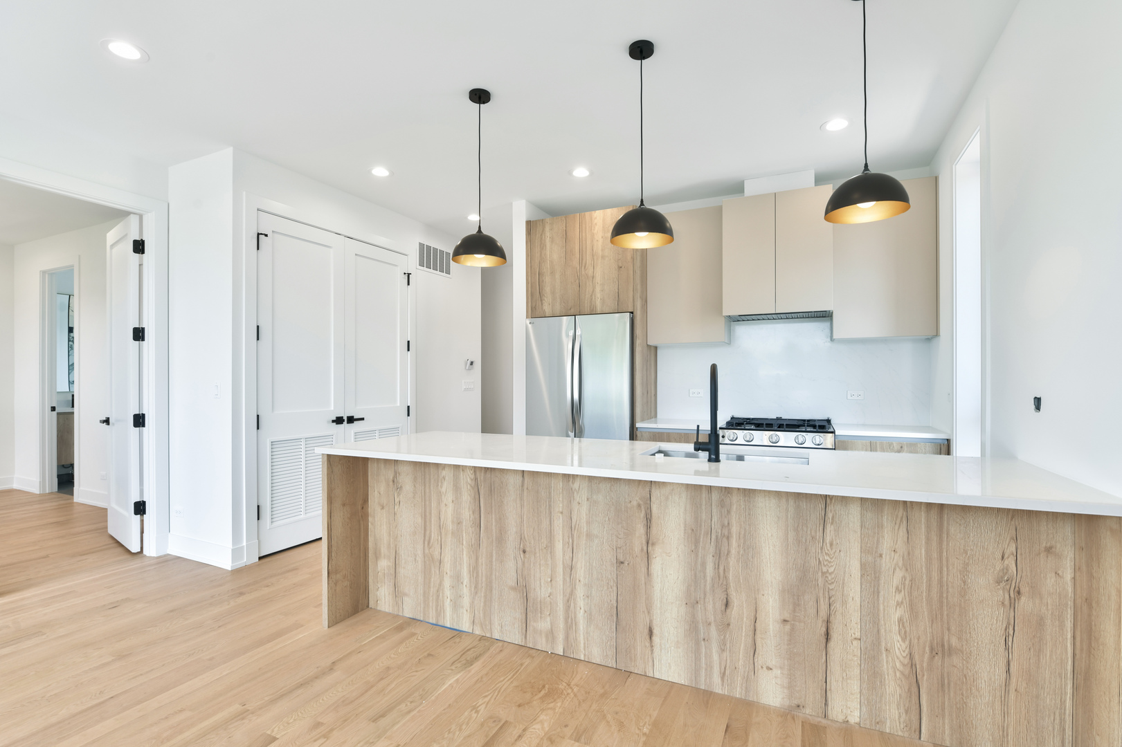 1244 North Kedzie Avenue, Unit 4 Chicago, IL 60651 - Photo 3 of 26 a large kitchen with stainless steel appliances kitchen island a large island in the center