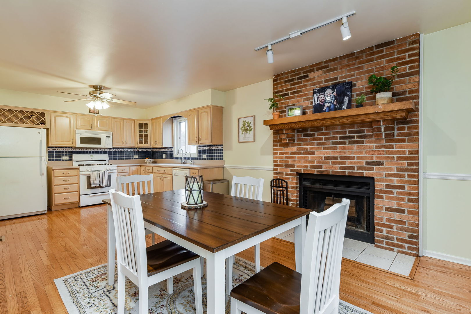 N020 Pleasant Hill Road Wheaton, IL 60187 - Photo 6 of 16 a kitchen with a table chairs refrigerator and cabinets