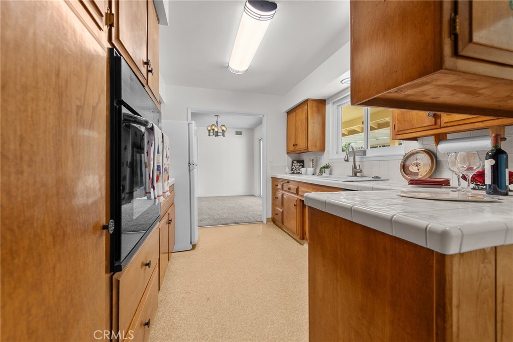 5593 Malvern Way Riverside, CA 92506 - Photo 12 of 54 a kitchen with stainless steel appliances granite countertop a sink and a refrigerator