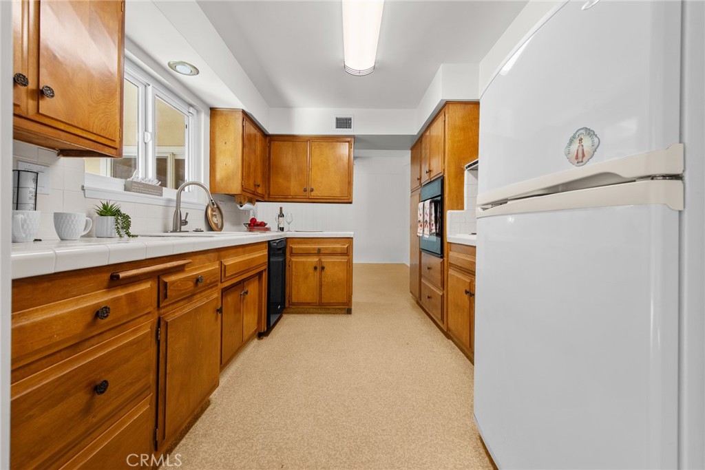 5593 Malvern Way Riverside, CA 92506 - Photo 13 of 54 a kitchen with a sink refrigerator and cabinets
