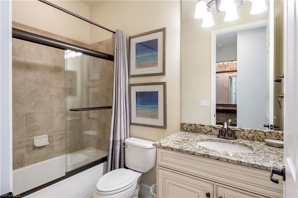 9487 Piacere Way Naples, FL 34113 - Photo 22 of 35 a bathroom with a granite countertop sink toilet and shower