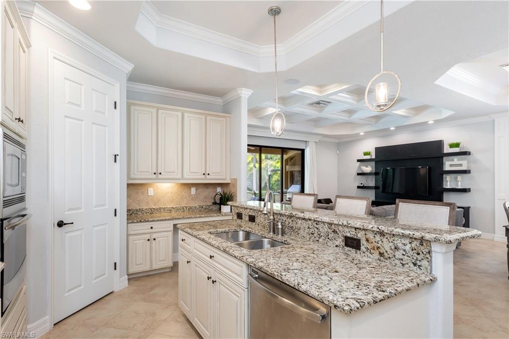 9487 Piacere Way Naples, FL 34113 - Photo 10 of 35 a kitchen with stainless steel appliances granite countertop a sink a stove top oven a counter space and cabinets