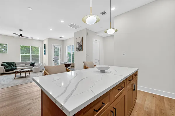 a living room with stainless steel appliances kitchen island furniture and wooden floor