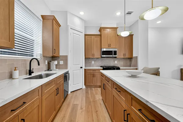 a kitchen with a sink stainless steel appliances and cabinets