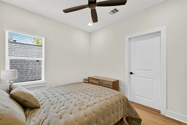 a bedroom with a bed and wooden floor