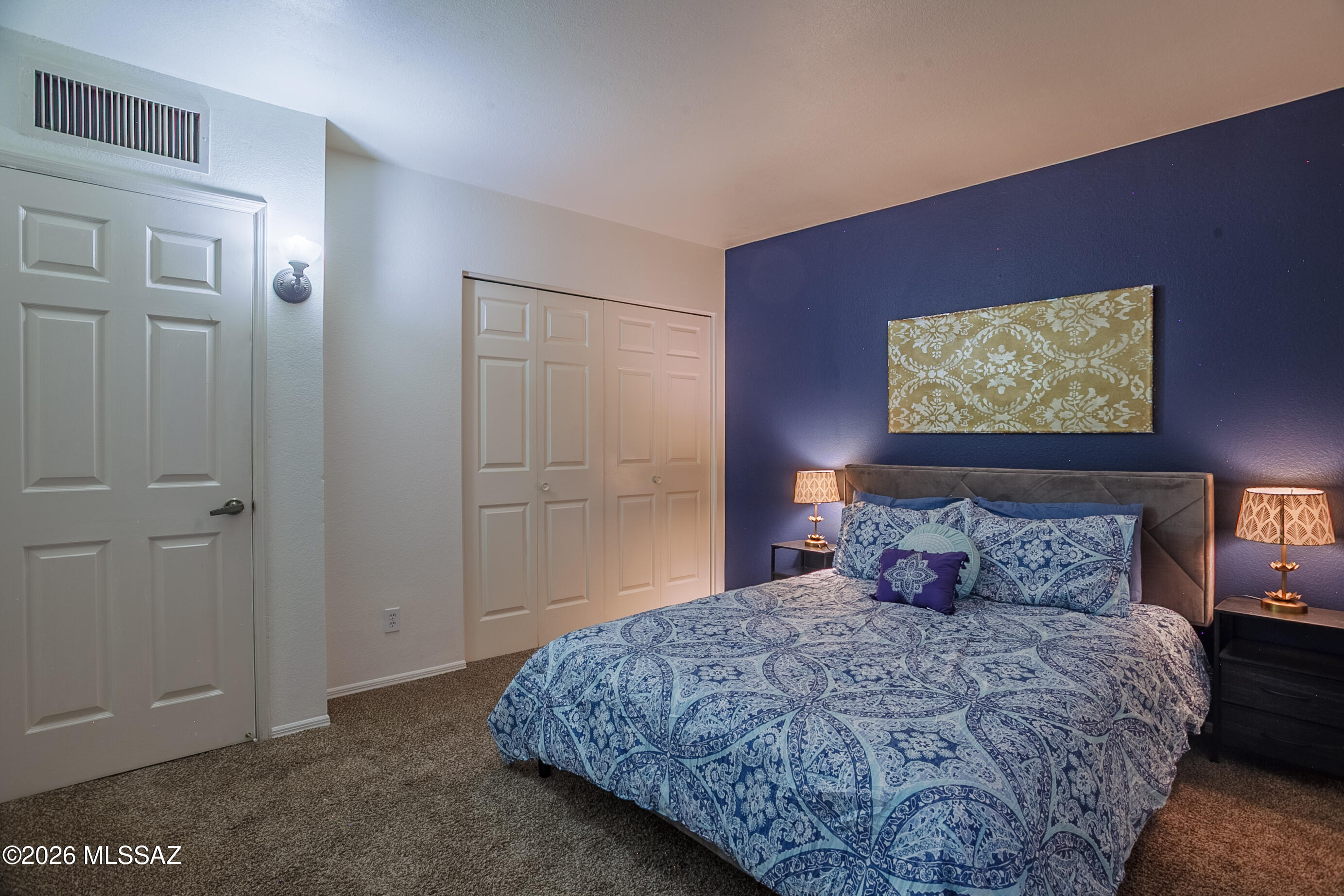 1200 East River Road, Unit B27 Tucson, AZ 85718 - Photo 21 of 40 a bedroom with a bed and a painting on the wall