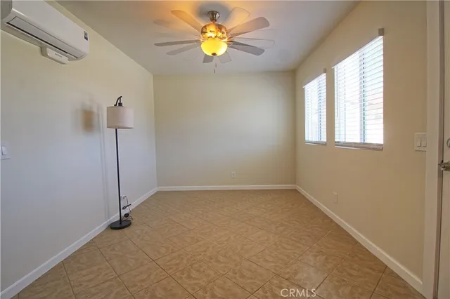 an empty room with a window and a fan