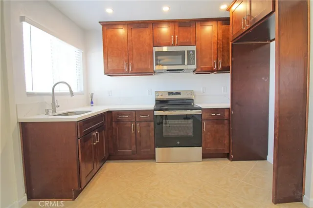 a kitchen with stainless steel appliances a sink stove and cabinets