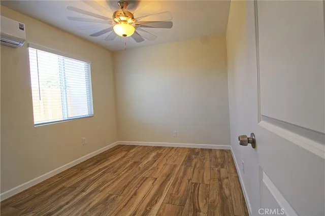 a view of a room with wooden floor and a window