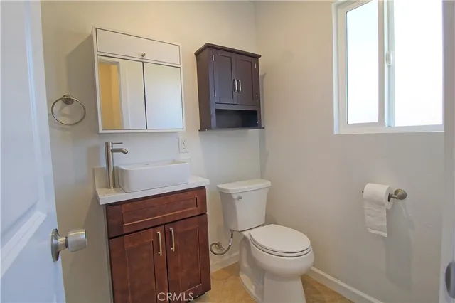 a bathroom with a toilet a sink and a window