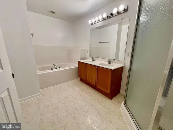 a bathroom with a tub sink and mirror