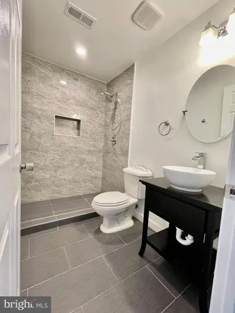 a bathroom with a toilet a sink and mirror