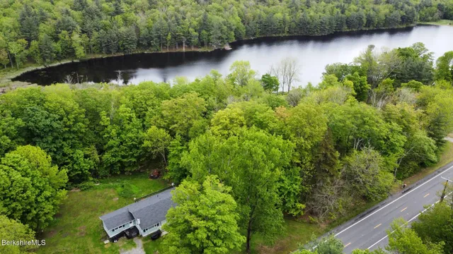 an aerial view of residential house with outdoor space and trees all around