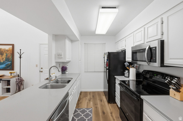 650 South Main Street, Unit 3304 Bountiful, UT 84010 - Photo 8 of 22 Galley kitchen featuring light wood-finish flooring, white cabinetry, a double basin stainless steel sink, light grey countertops, and a full suite of black and stainless steel appliances