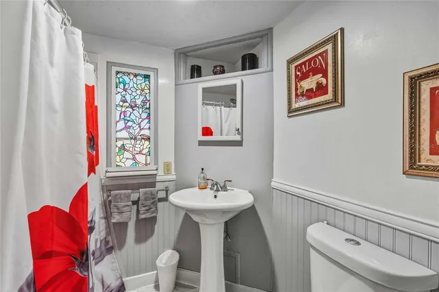 a bathroom with a toilet sink and mirror