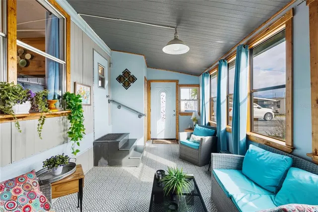 a living room with furniture potted plant and a large window