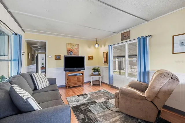 a living room with furniture windows and a flat screen tv