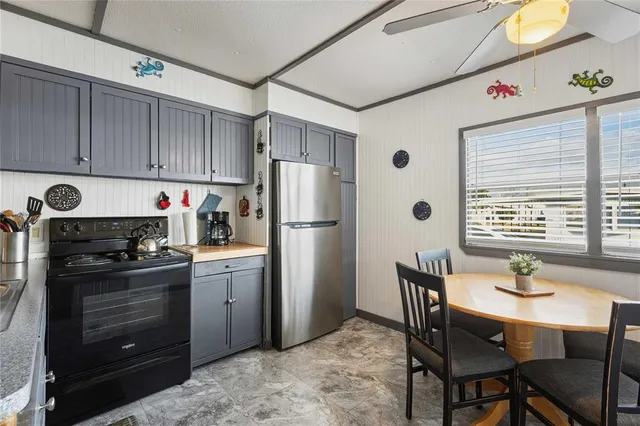a kitchen with a stove a refrigerator and dining table