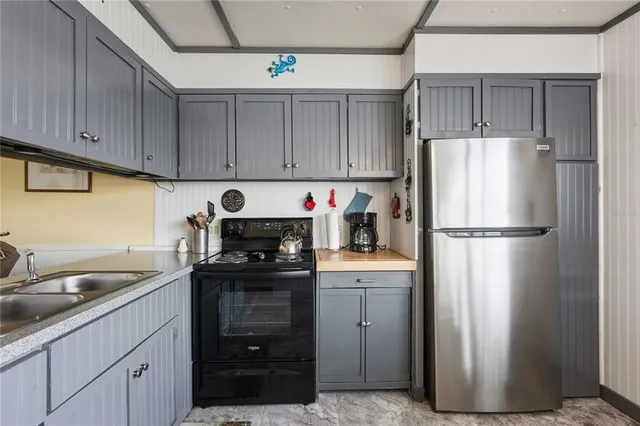a kitchen with a refrigerator sink and cabinets