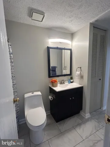a bathroom with a sink vanity mirror and toilet