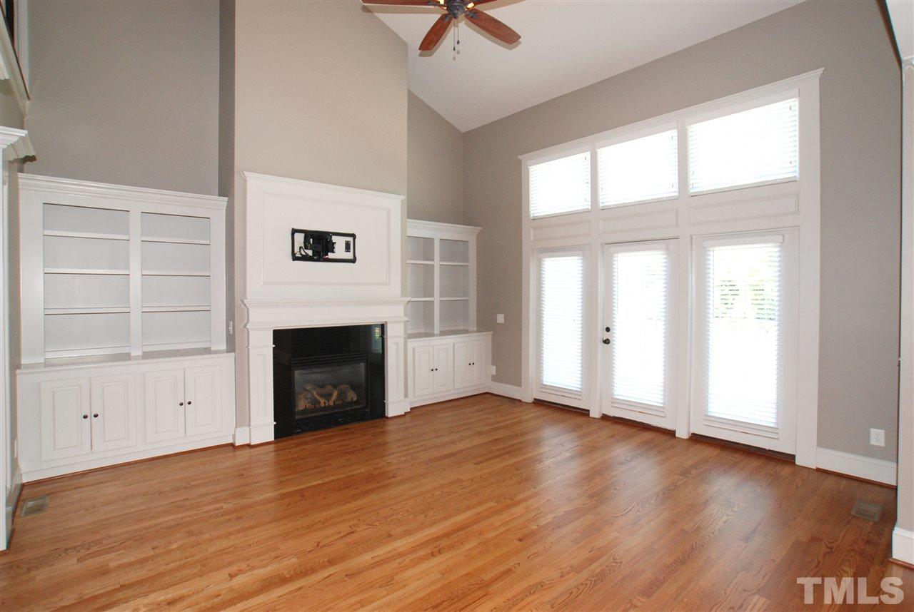 8012 Lloyd Allyns Way Raleigh, NC 27615 - Photo 7 of 25 The Family Room features Built-ins, Gas Fireplace, Remote Control Ceiling Fan & Glass Door that opens to the Deck. This Home has Plantation Blinds through out & Hardwood Flooring on all of the 1st Level with the exception of the Tiled Laundry Room.