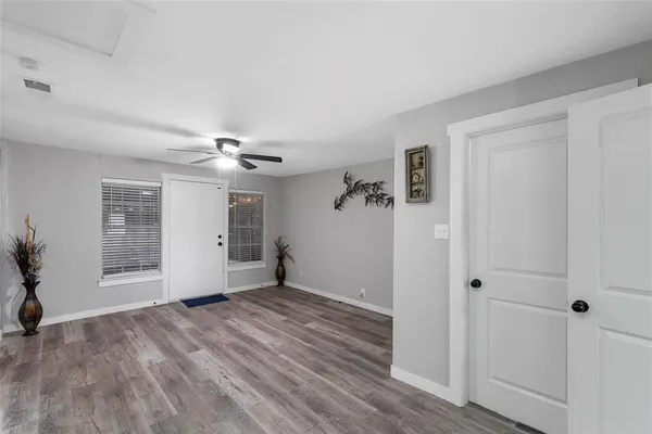 a view of a livingroom with wooden floor and a ceiling fan
