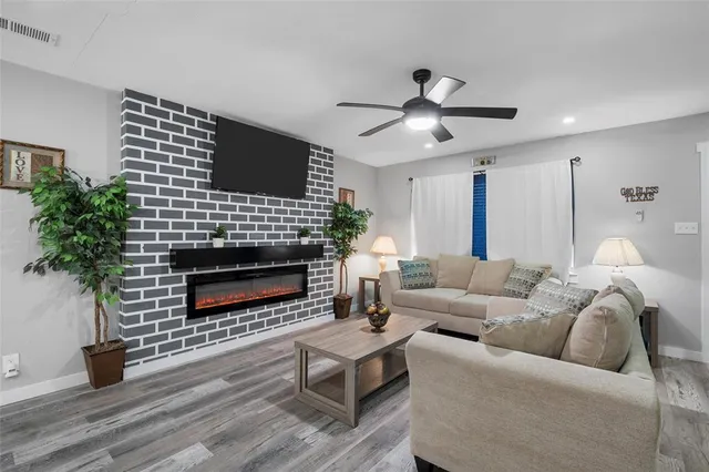 a living room with furniture a fireplace and a potted plant