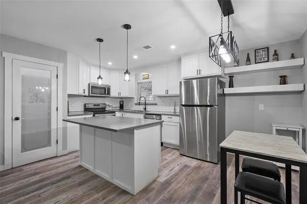 a kitchen with refrigerator cabinets and wooden floor