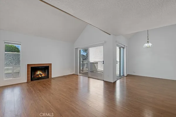 an empty room with wooden floor and fireplace